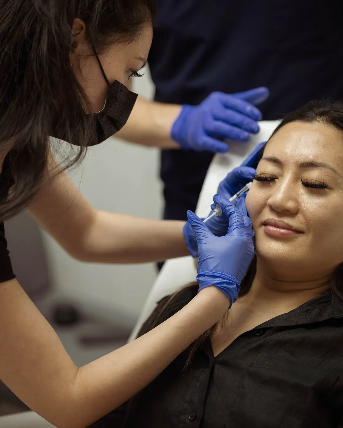 Participante injectant un neuromodulateur sur le visage d’une patiente sous supervision de la faculté