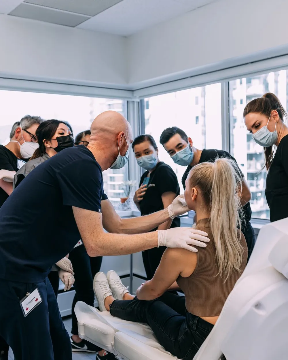 Faculty injector demonstrating filler technique to a small group of course participants